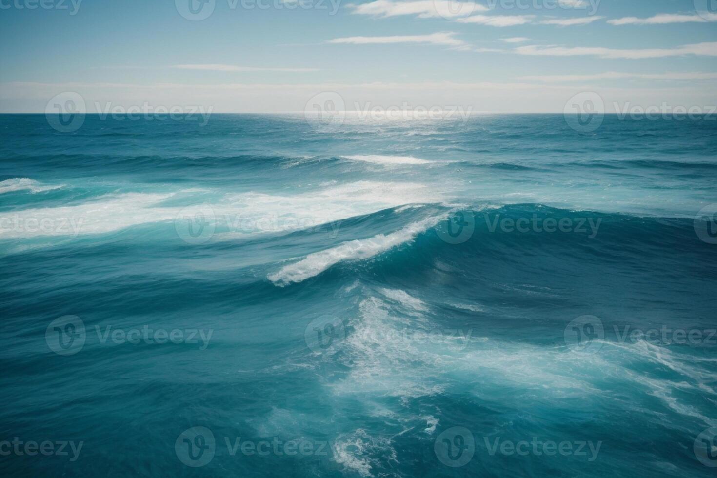 a beautiful blue ocean with waves and clouds photo