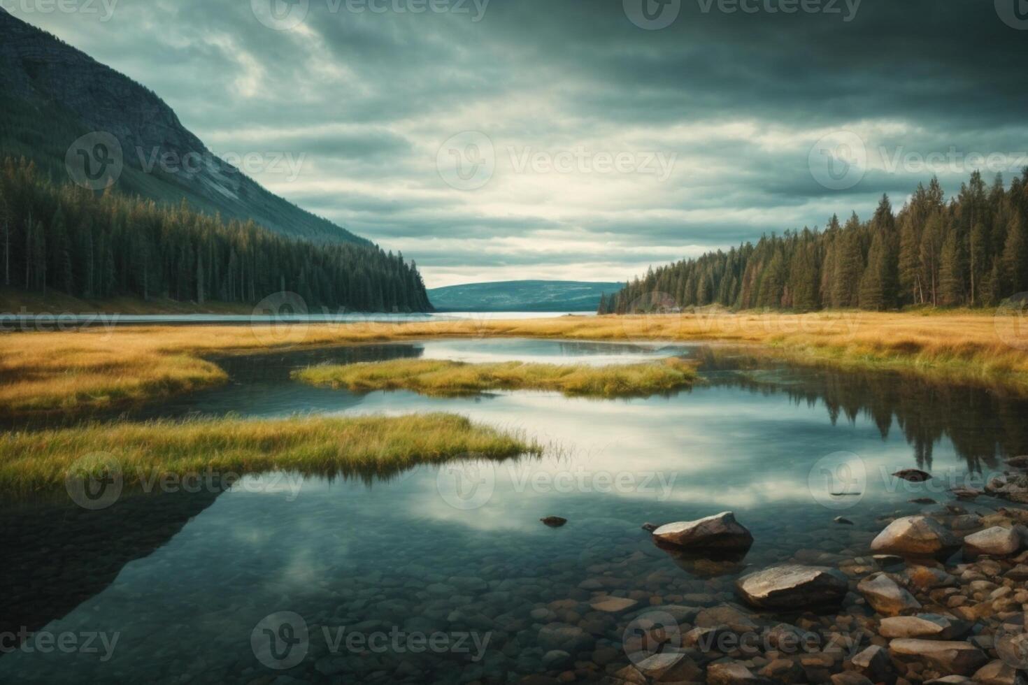 a mountain lake surrounded by grass and trees photo