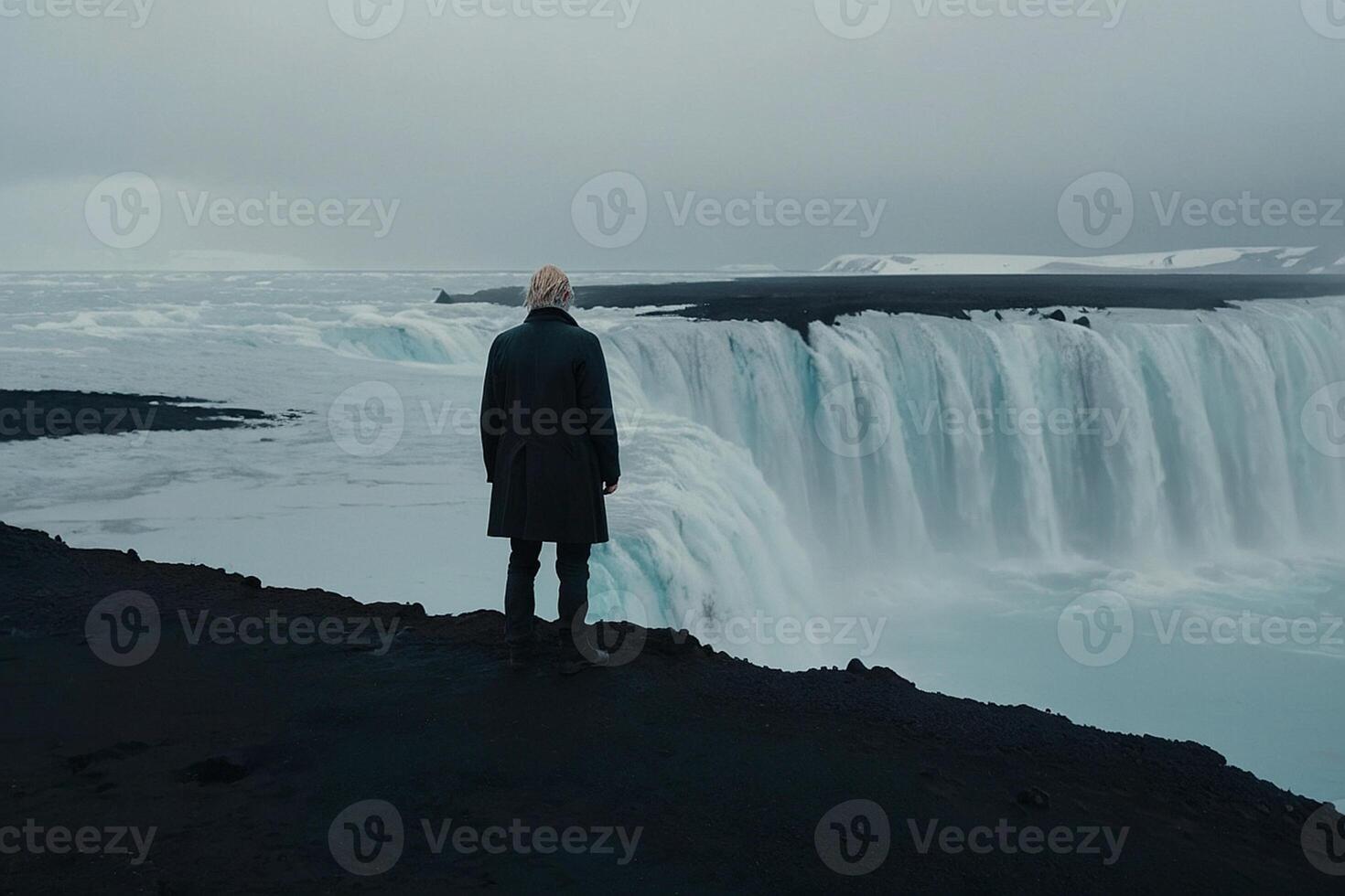 hombre en pie en el borde de un cascada mirando a el Oceano foto