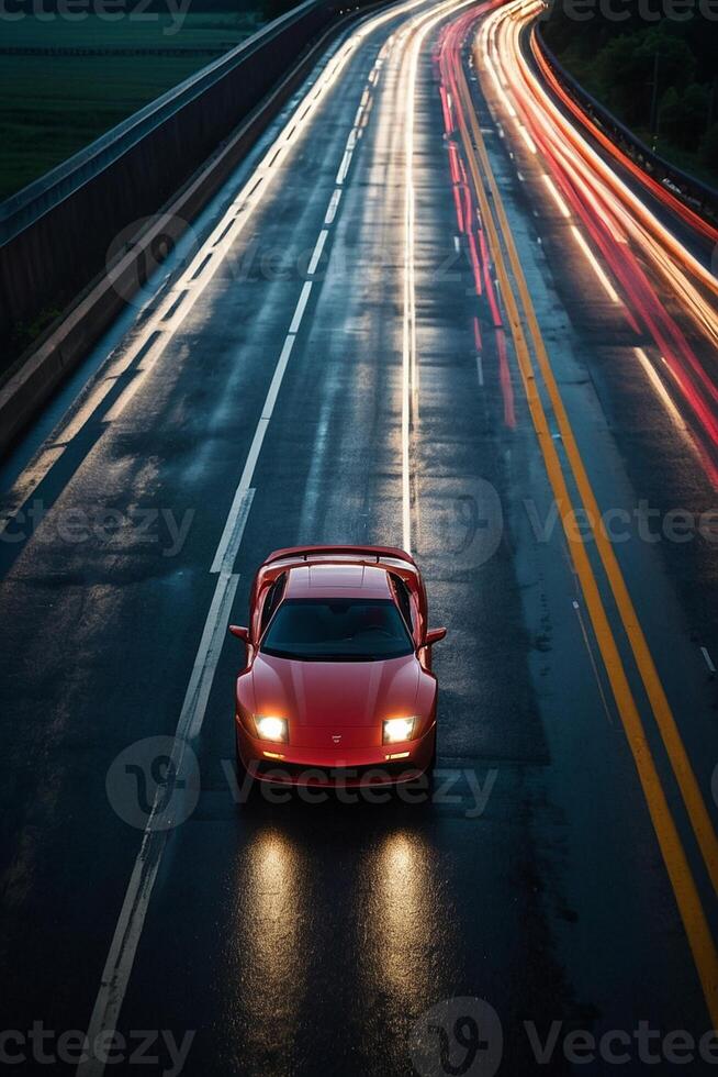 a sports car driving on a wet road at night photo