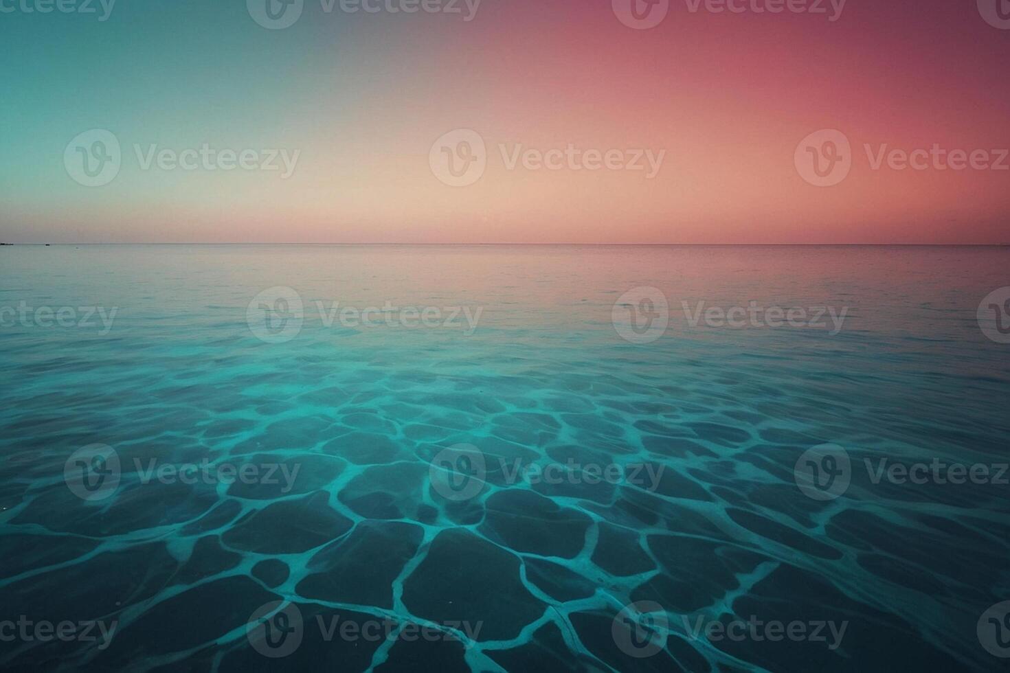 a blue ocean with ripples and a pink sky photo