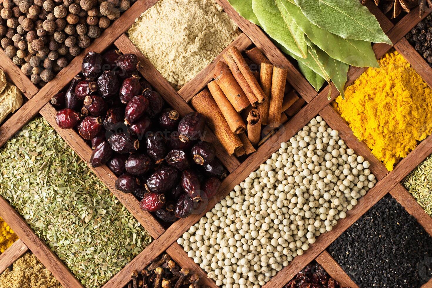 Spices and herbs for decorating food labels . Seasoning in wooden box as background, top view. photo
