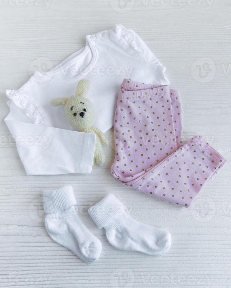 Set of baby bodysuits, pants, socks and knitted toy photo