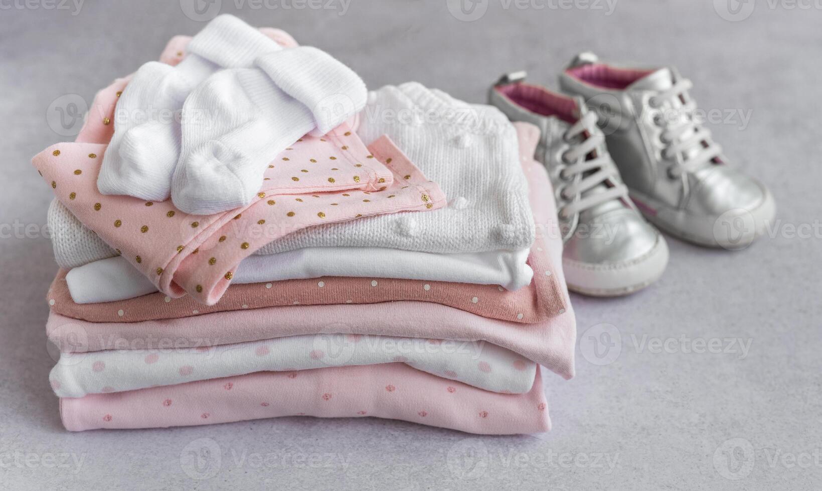 Stack of Baby bodysuits on a grey background. photo
