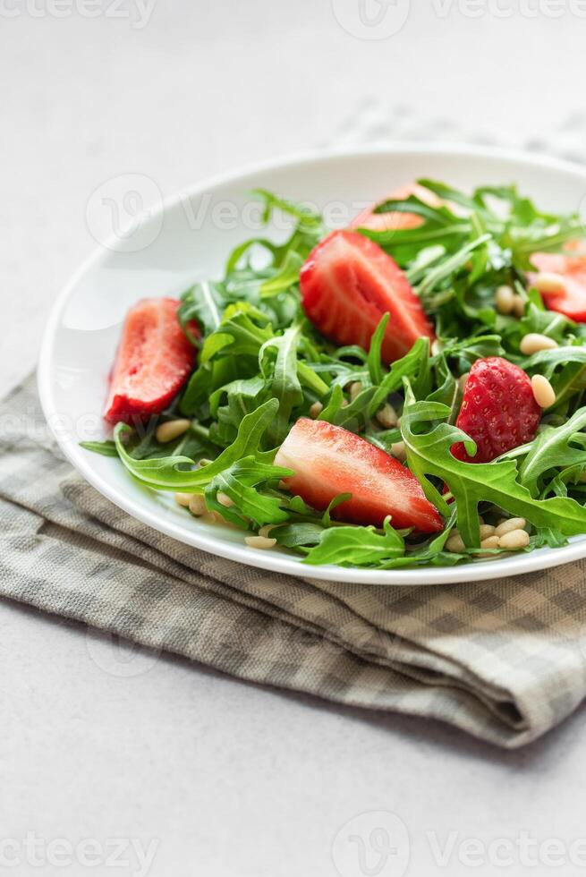 Fresh Strawberry Arugula Salad With Pine Nuts Served on a Bright Day photo