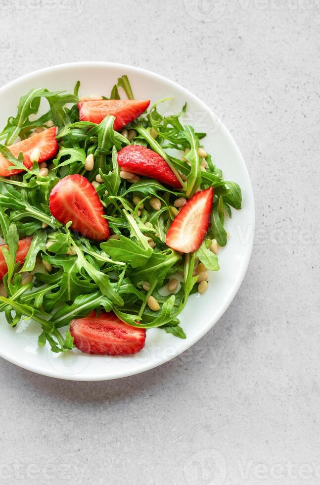 Fresh Strawberry Arugula Salad With Pine Nuts Served on a Bright Day photo