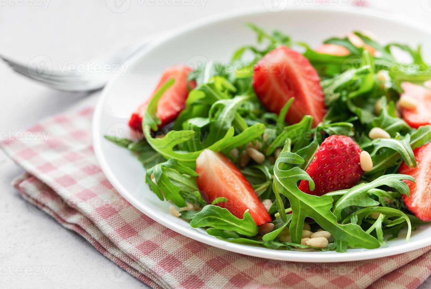 Fresh Strawberry Arugula Salad With Pine Nuts Served on a Bright Day photo