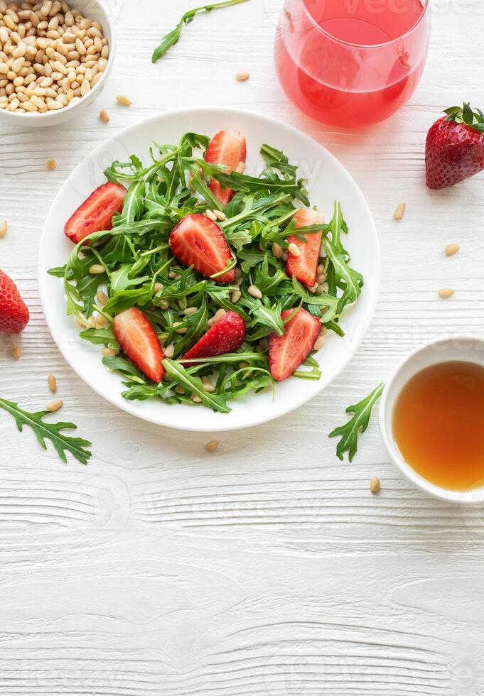 Fresh Strawberry Arugula Salad With Pine Nuts Served on a Bright Day photo