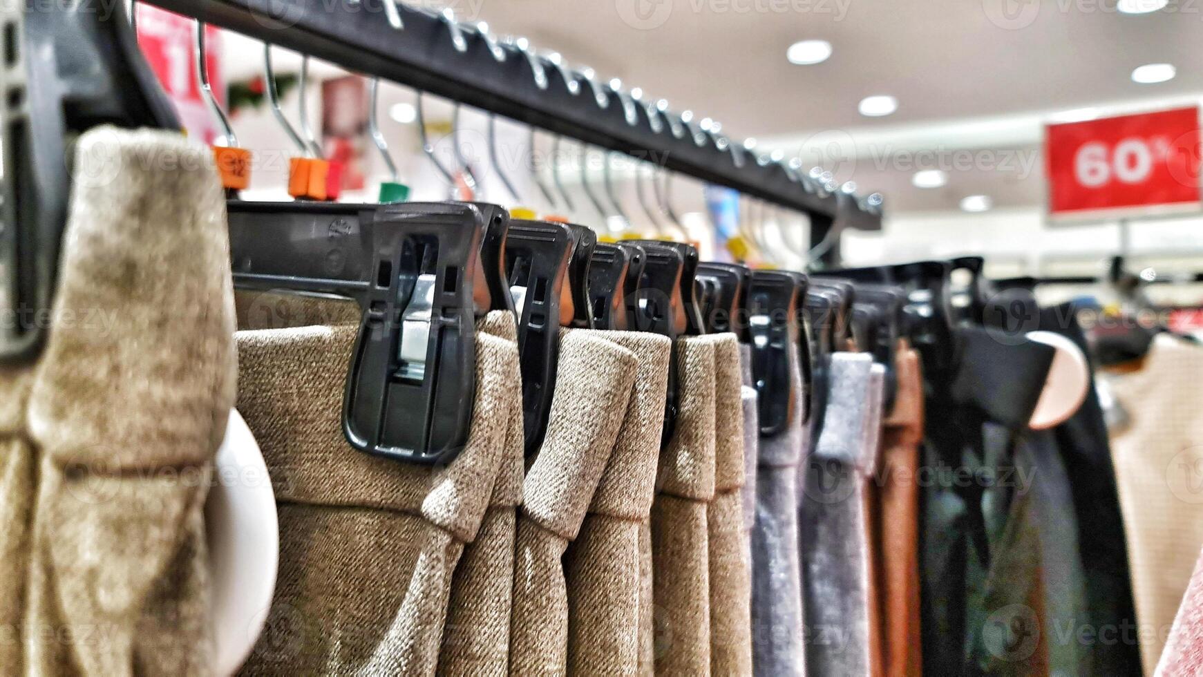 Rows of trousers in a clothing store hanging neatly on hangers. photo