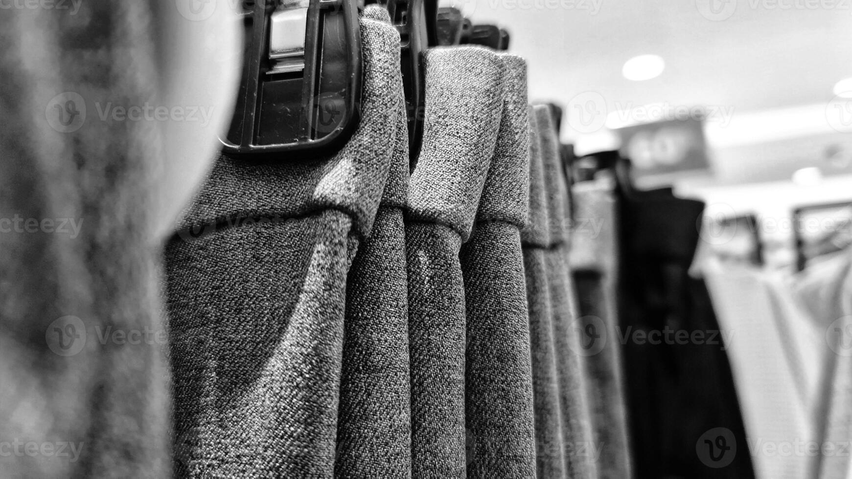 Rows of trousers in a clothing store hanging neatly on hangers. photo