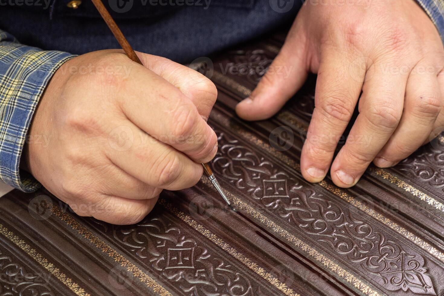 Bookbinder makes a unique cover for book. Handmake leather bookcover. photo