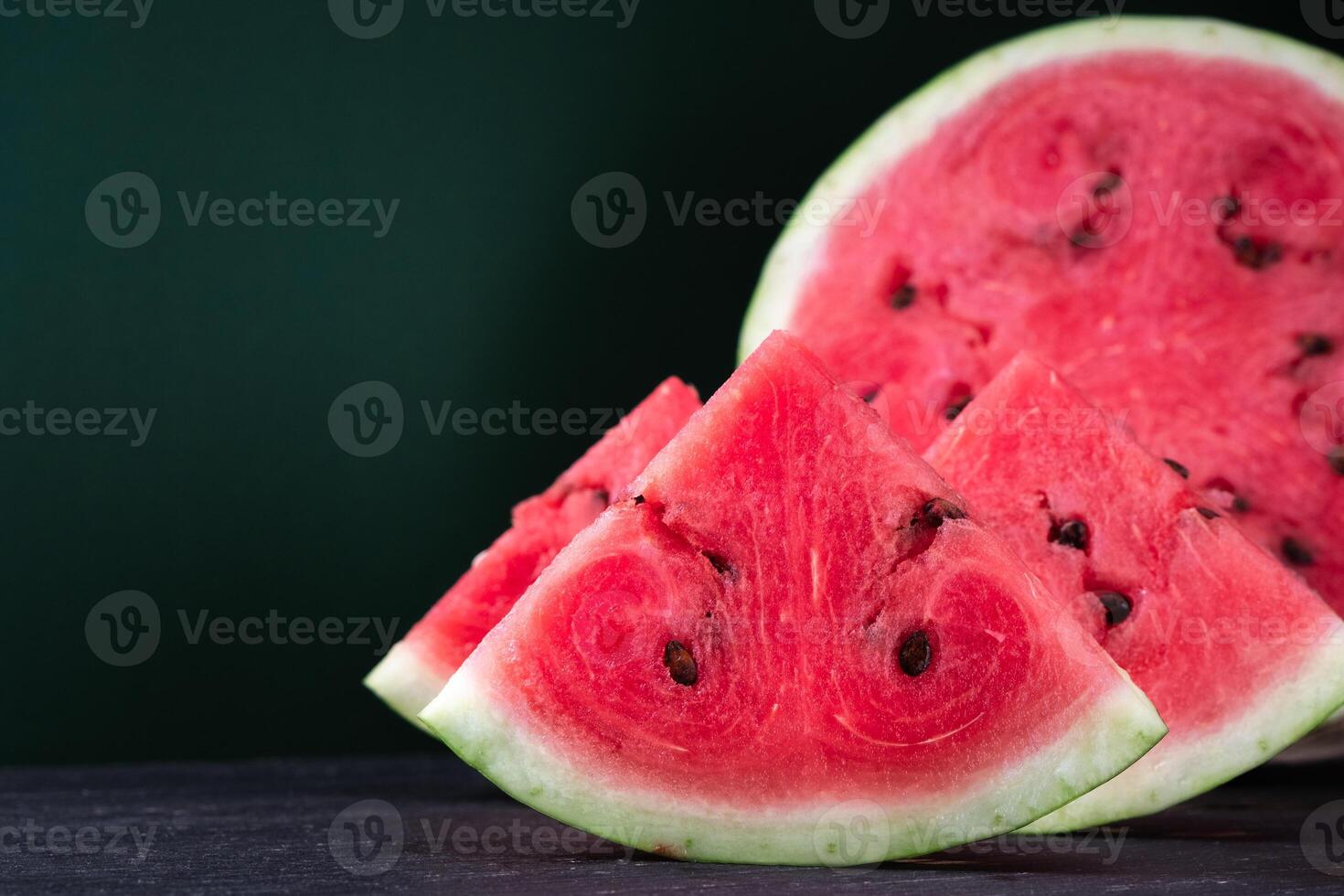 Pieces of refreshing watermelon on a dark wood background. Close-up photo. Fruit texture photo
