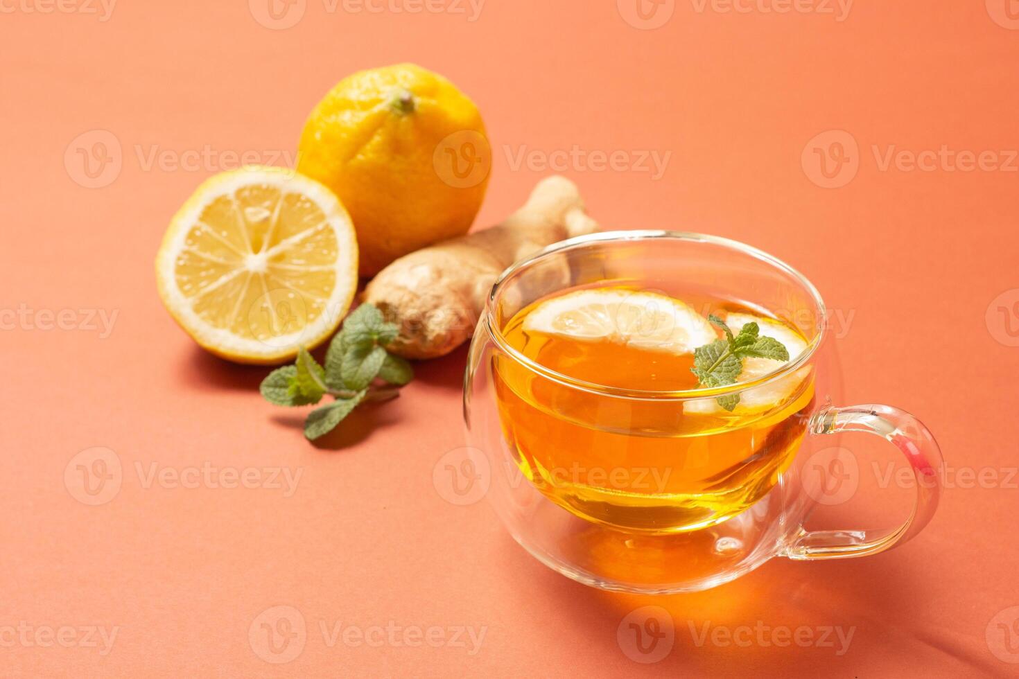 Ginger tea with mint and lemon. Healthy drink. Crystal cup on bright background. Selective focus. photo