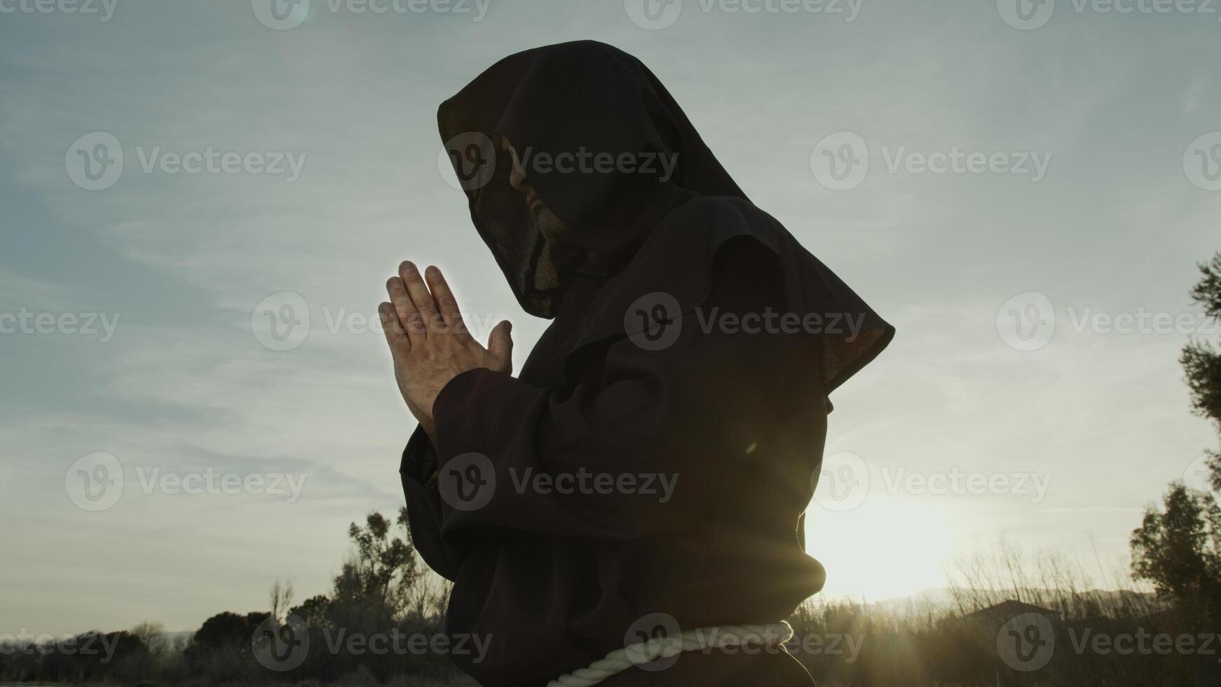 Silhouette Of A Monk Stands Praying On The Nature photo
