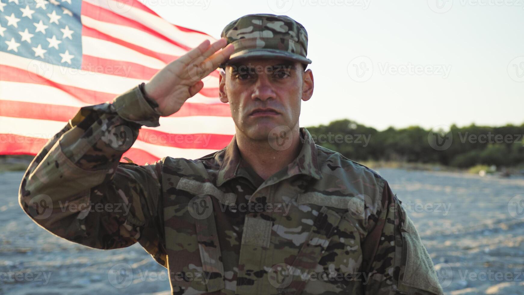 Military standing at attention next to the flag of their nation photo