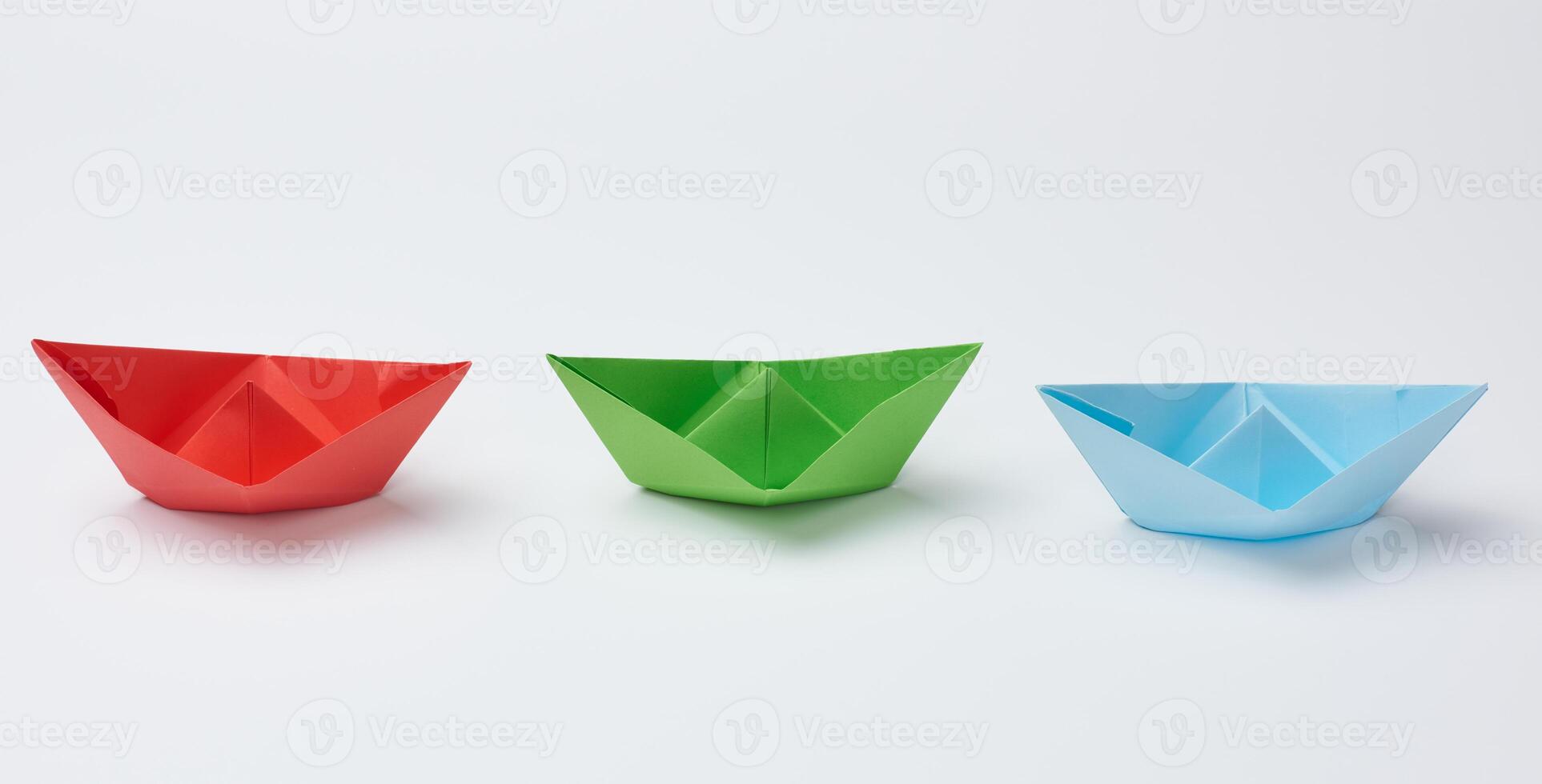 Three paper boats on a white background photo