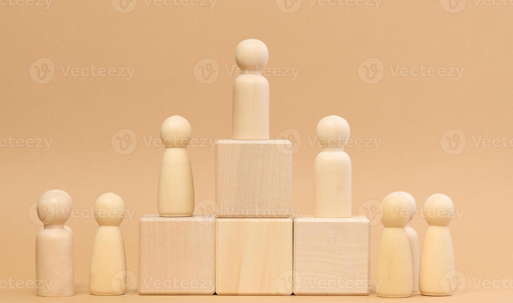 Wooden figures of men stand on a pedestal. The concept of rivalry in sports, business and life. Achieving success photo
