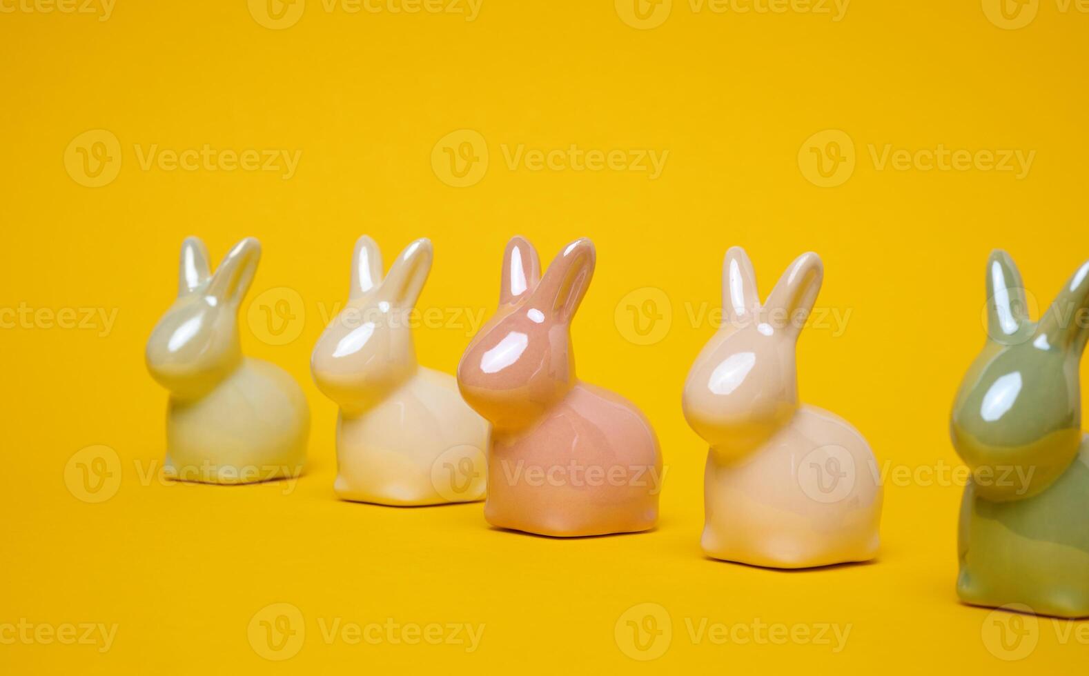 Ceramic decorative bunnies on a yellow background, festive Easter background photo