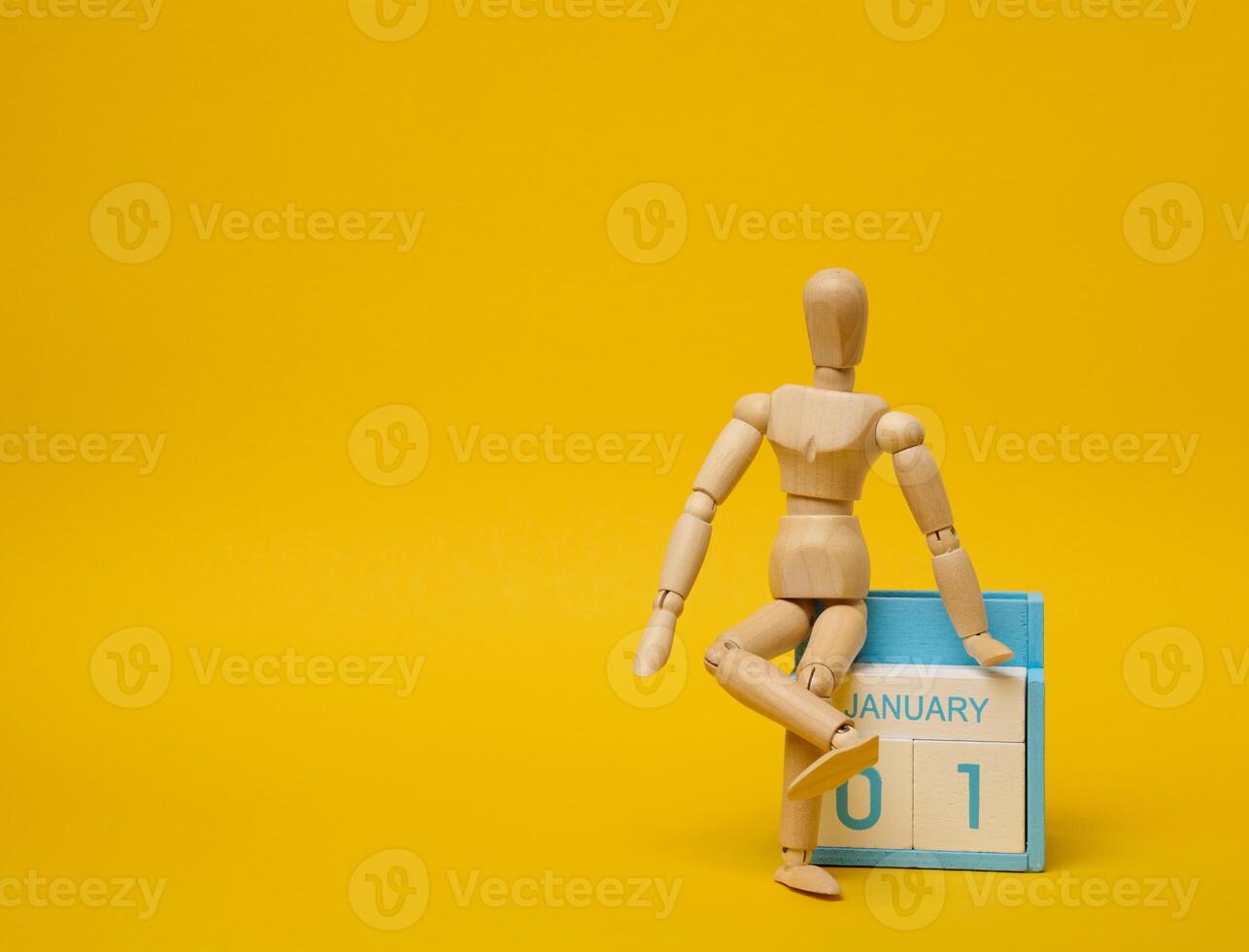 Wooden puppet and calendar with the date the first of September on a yellow background photo