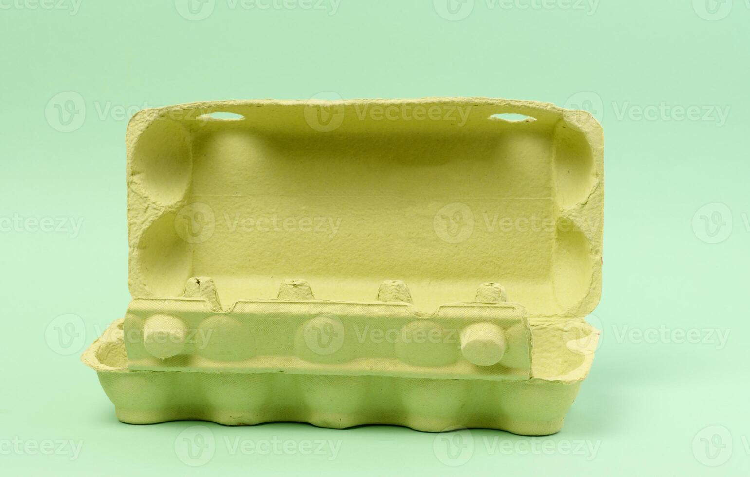 Open green recycled egg carton box on green background, storage photo
