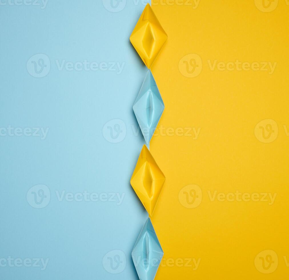 Paper boats on a yellow background, top view, representing the concept of unity and achieving common goals. photo