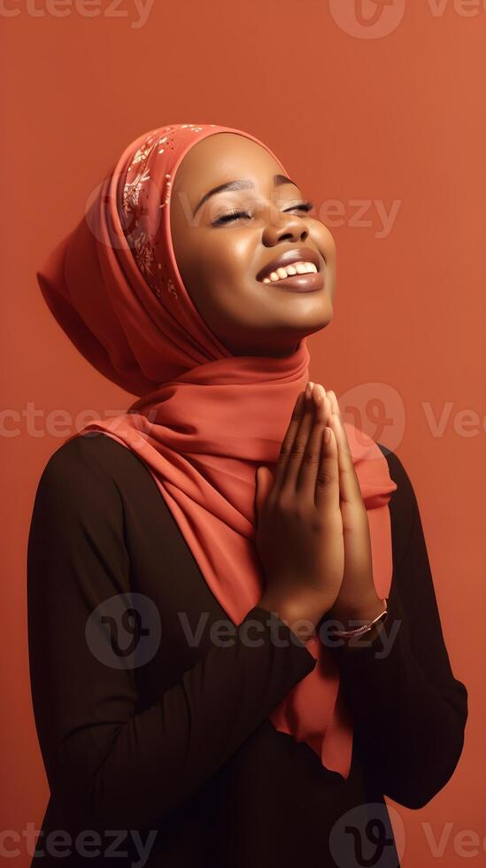 African woman wearing scarf is praying and smiling on red background photo