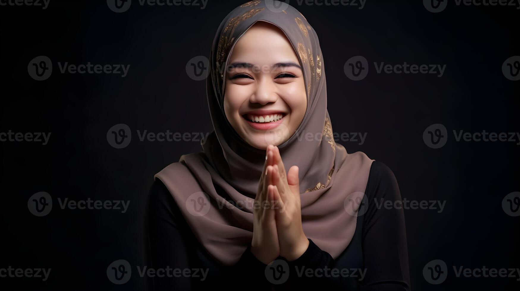 Southeast asian woman wearing scarf is praying and smiling on black background photo