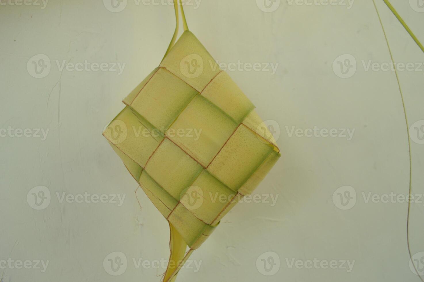 Ketupat isolated on white background. A typical Eid al-Fitr dish made from rice wrapped in a wrap made from woven young coconut leaves. typical Malay and Indonesian food photo