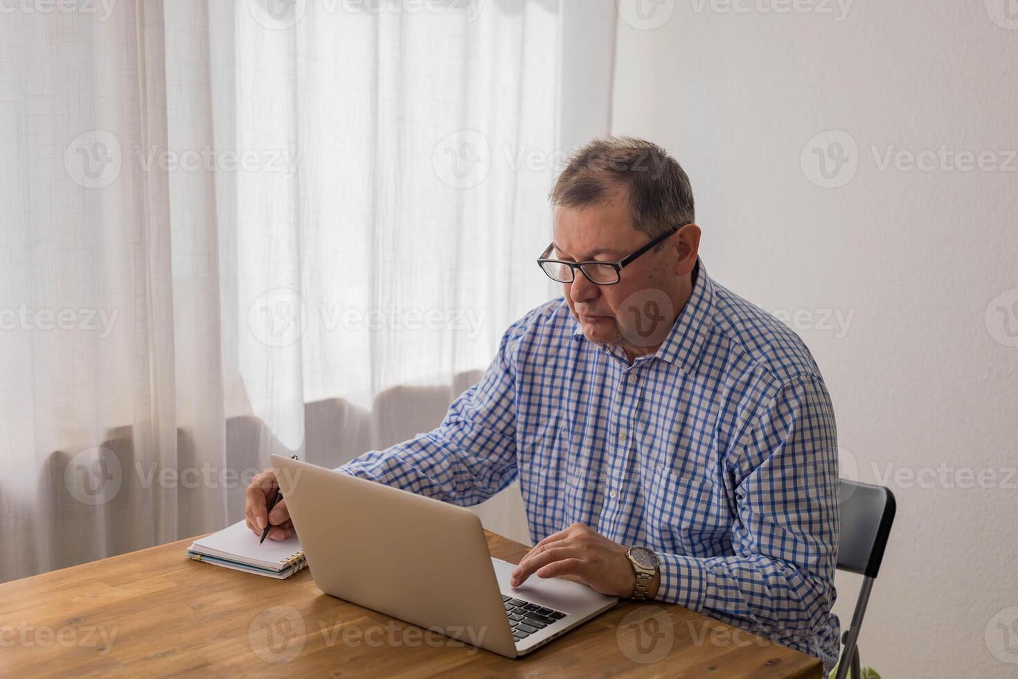 Senior man working on laptop in the home photo