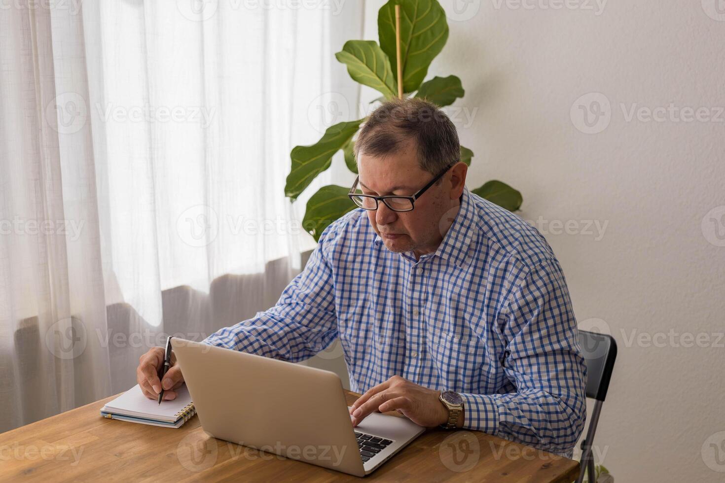 Senior man working on laptop in the home photo