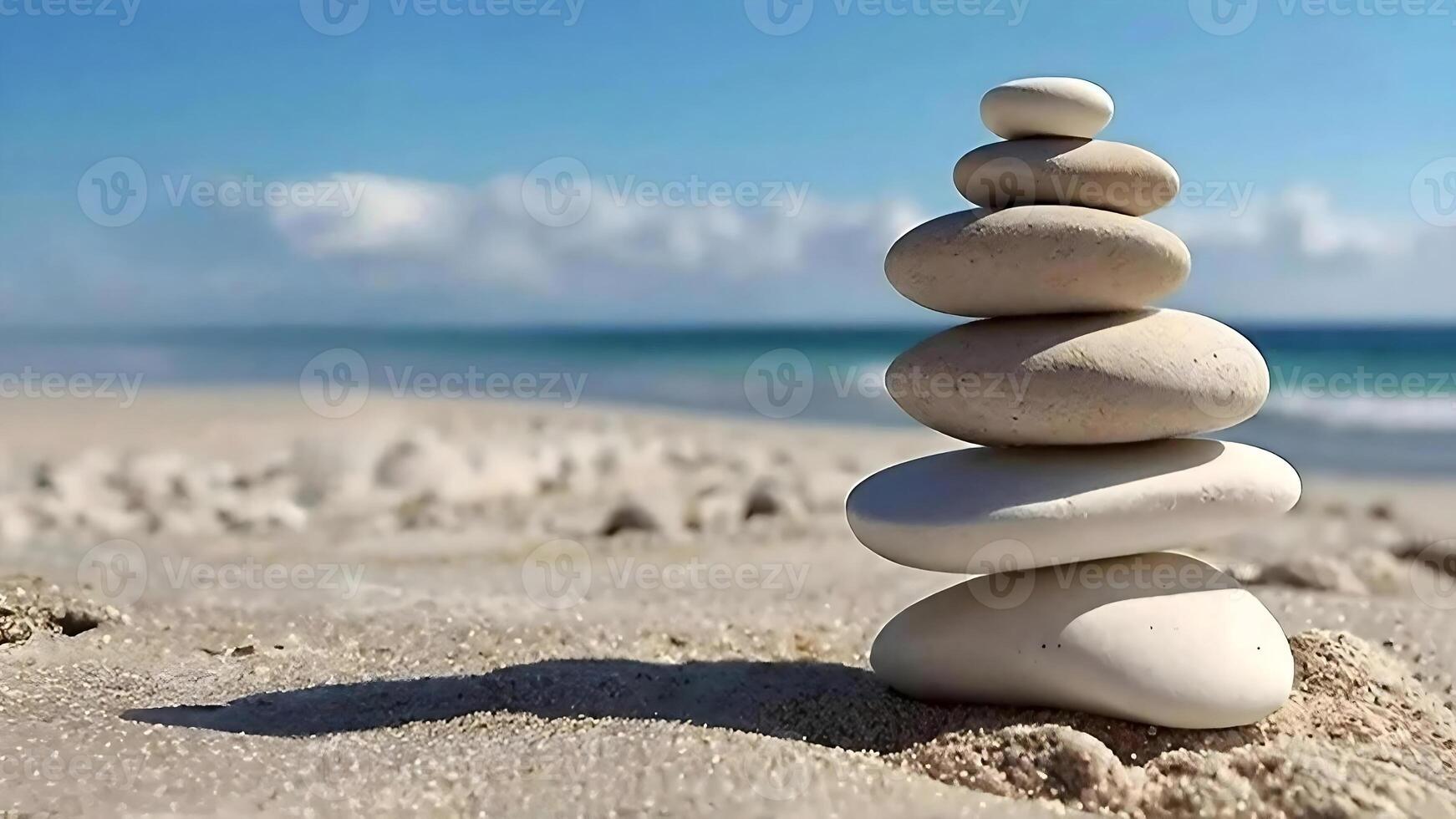Stack of pebble stones on a white sandy beach under blue sky, balance and harmony image concept photo