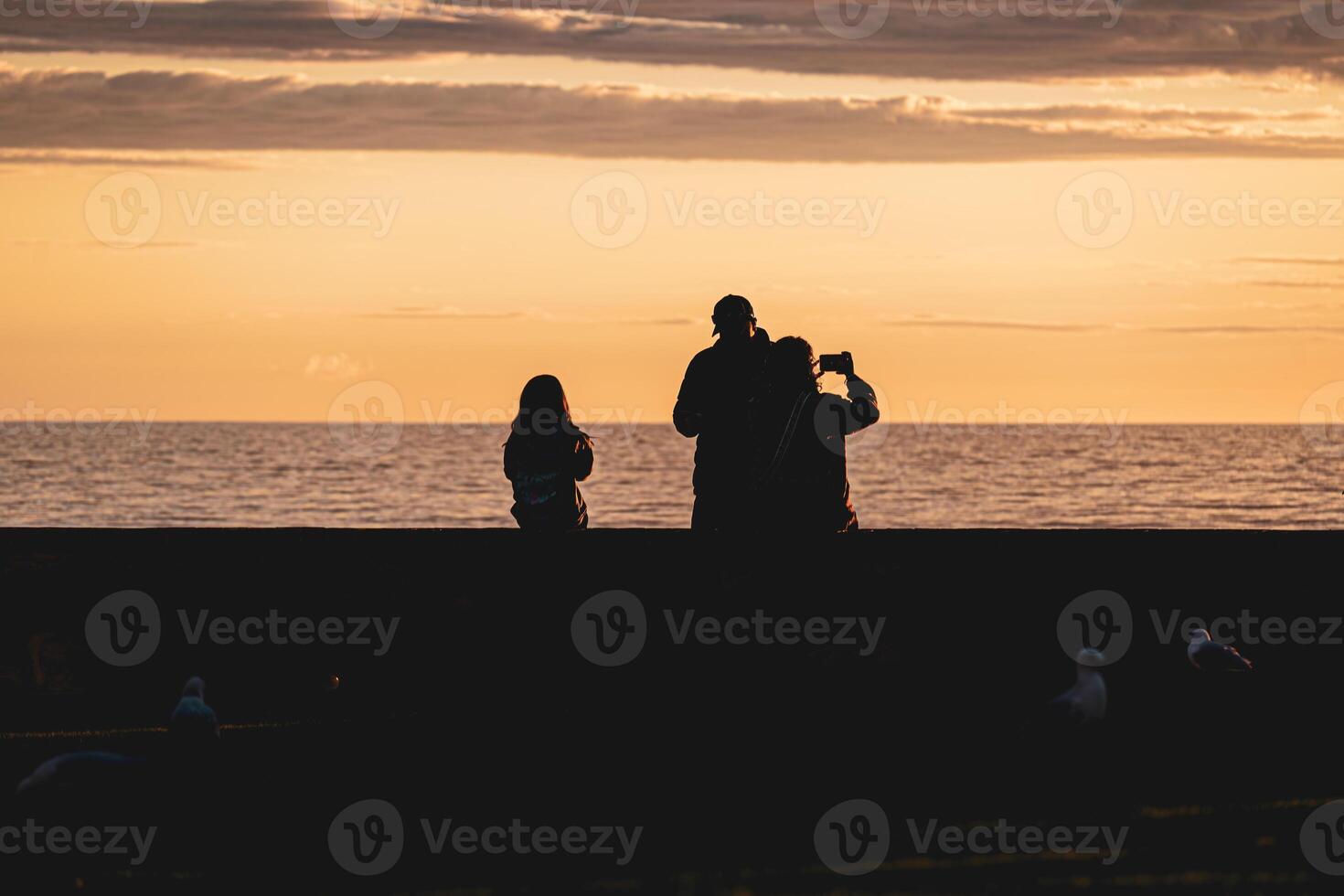 puesta de sol siluetas por el mar foto