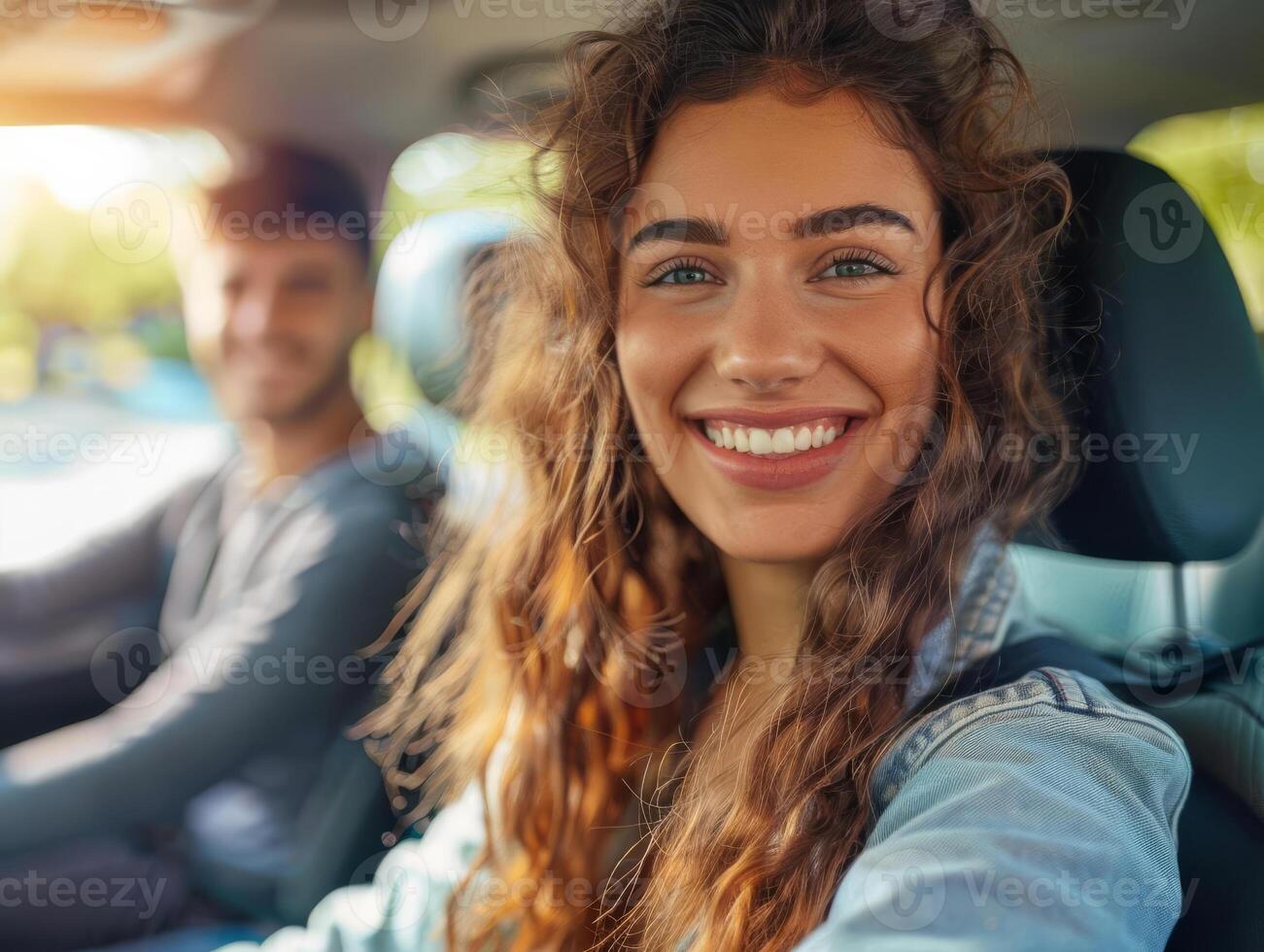 A woman with long hair is smiling and taking a selfie in a car photo
