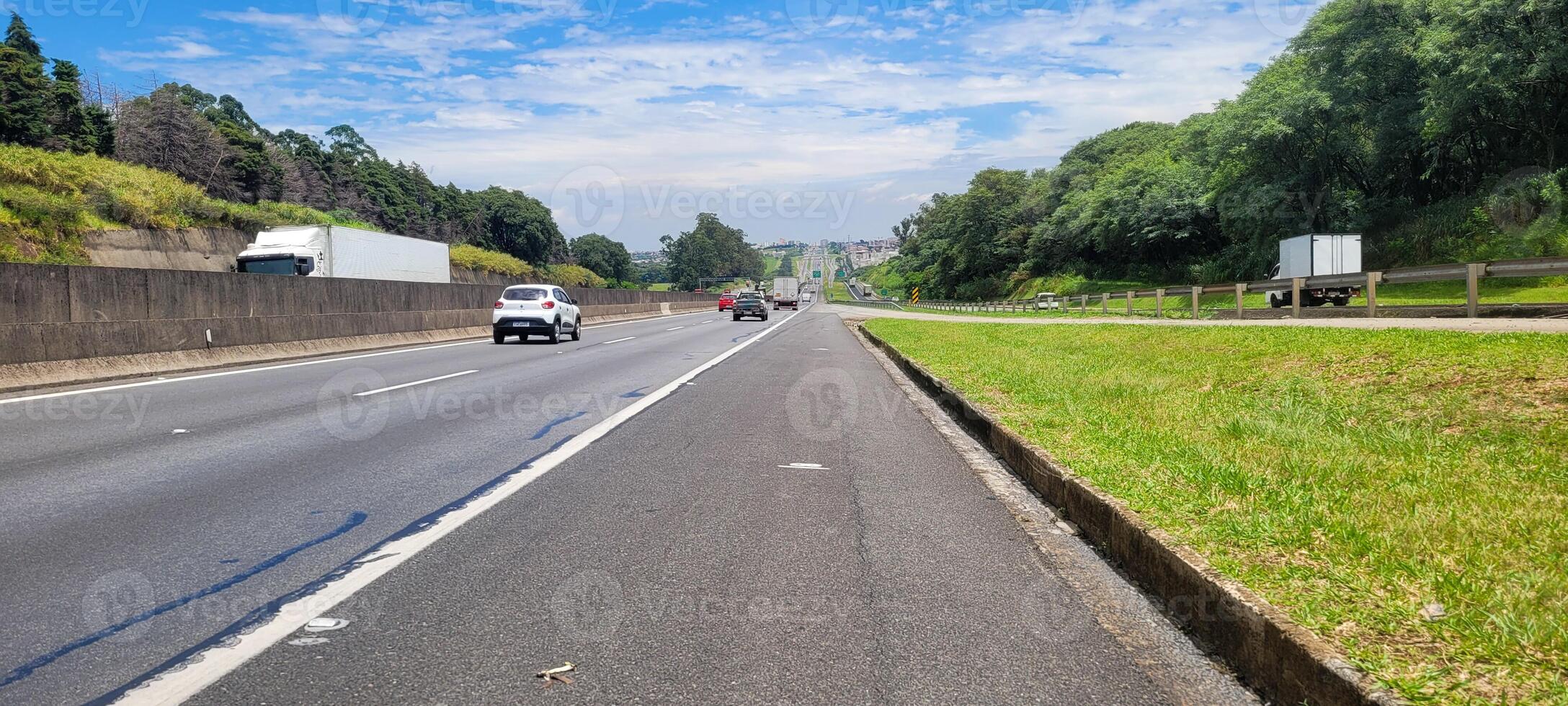 paved road with cars passing by on a sunny day in campinas photo