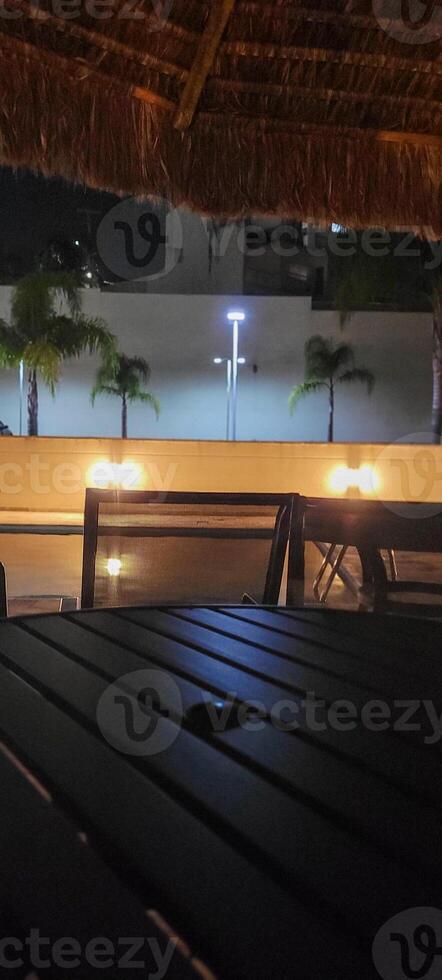 image of dark table in garden with pool at night photo
