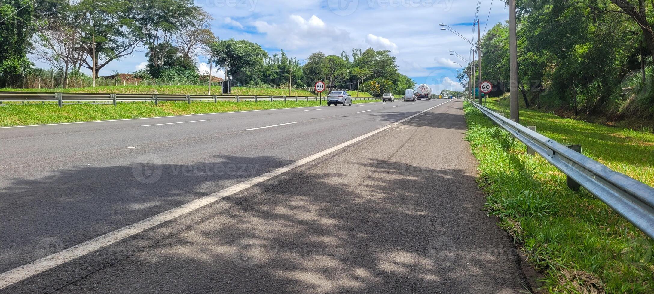 paved road with cars passing by on a sunny day in campinas photo