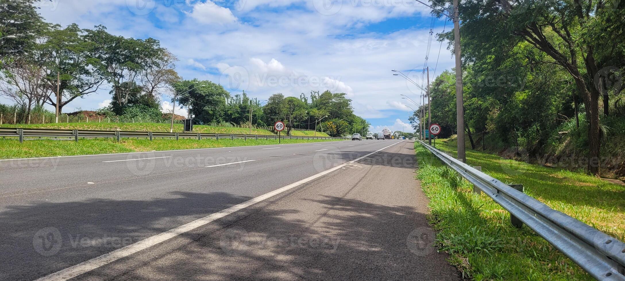 paved road with cars passing by on a sunny day in campinas photo