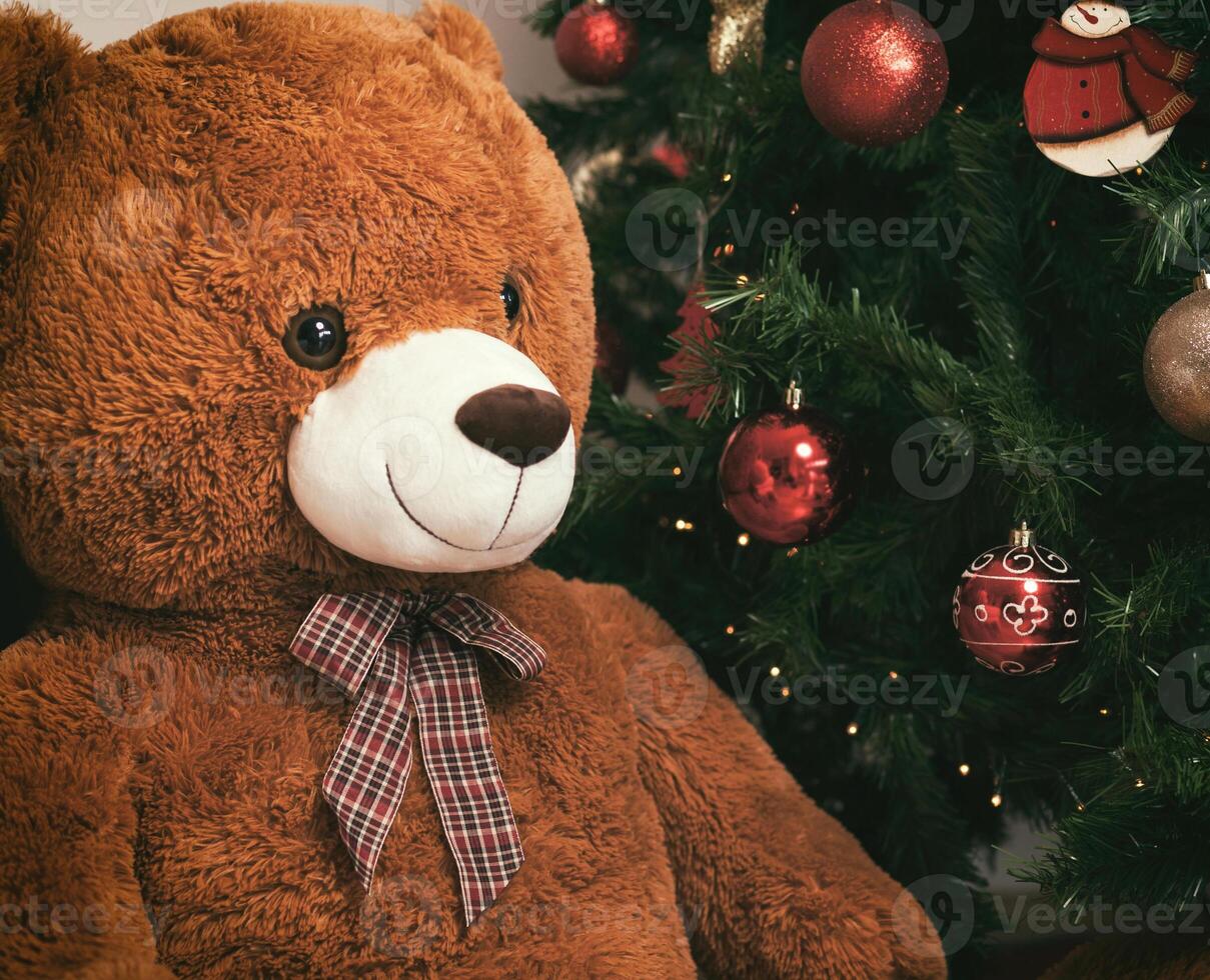 Teddy bear near christmas tree with gifts photo