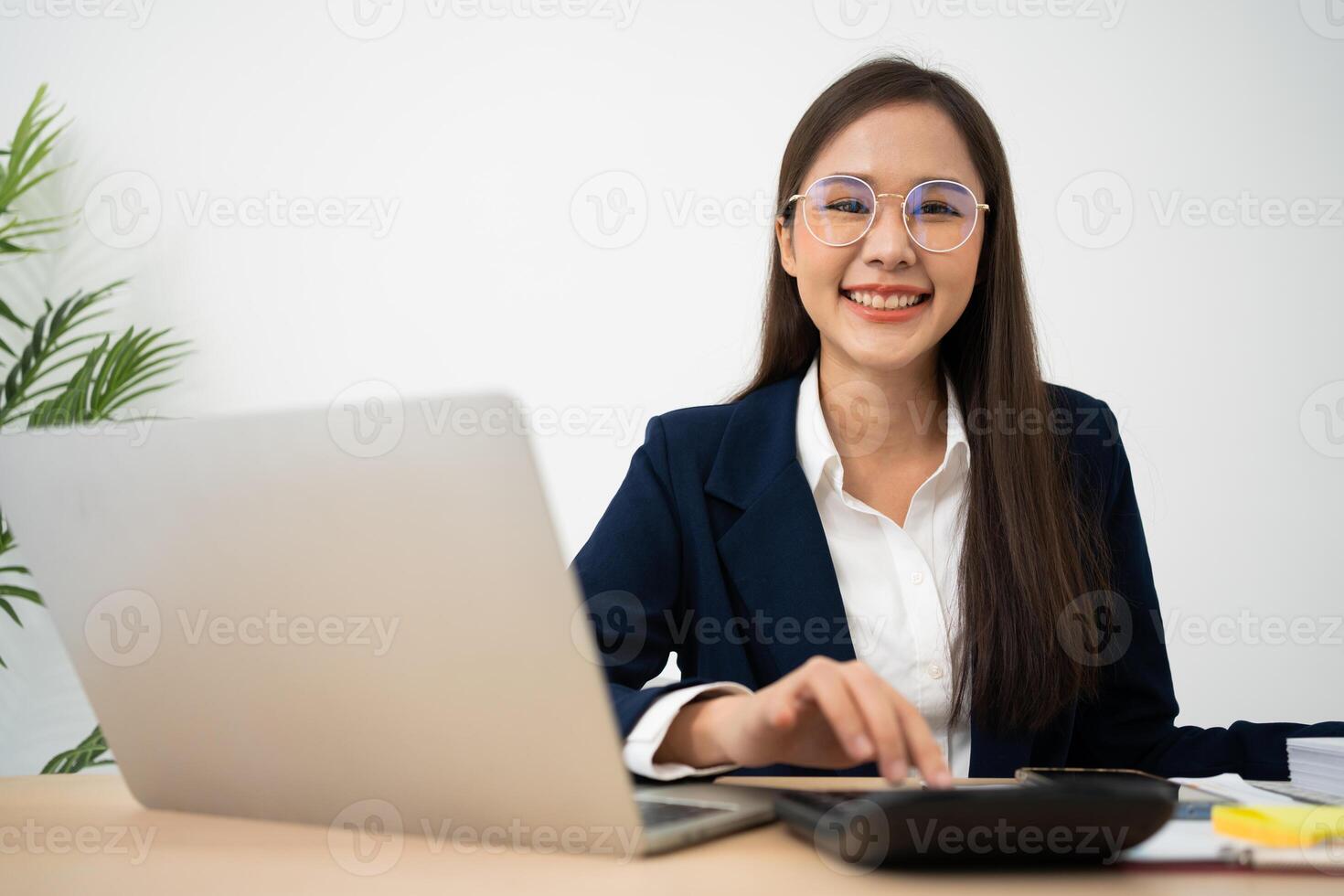 retrato de sonriente hermosa negocio asiático mujer a moderno oficina escritorio utilizando ordenador portátil a trabajo y escribir notas, negocio personas empleado Lanza libre en línea márketing comercio electrónico telemarketing concepto. foto