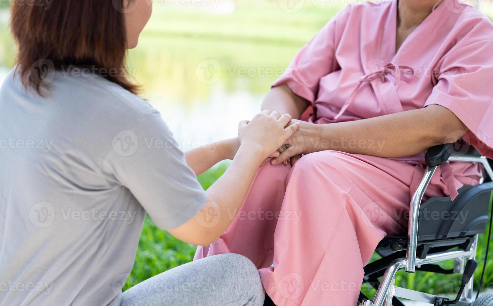 Asian careful caregiver or nurse taking care of the patient in a wheelchair. Concept of a happy retirement with care from a caregiver and Savings and senior health insurance, encourage the patient photo