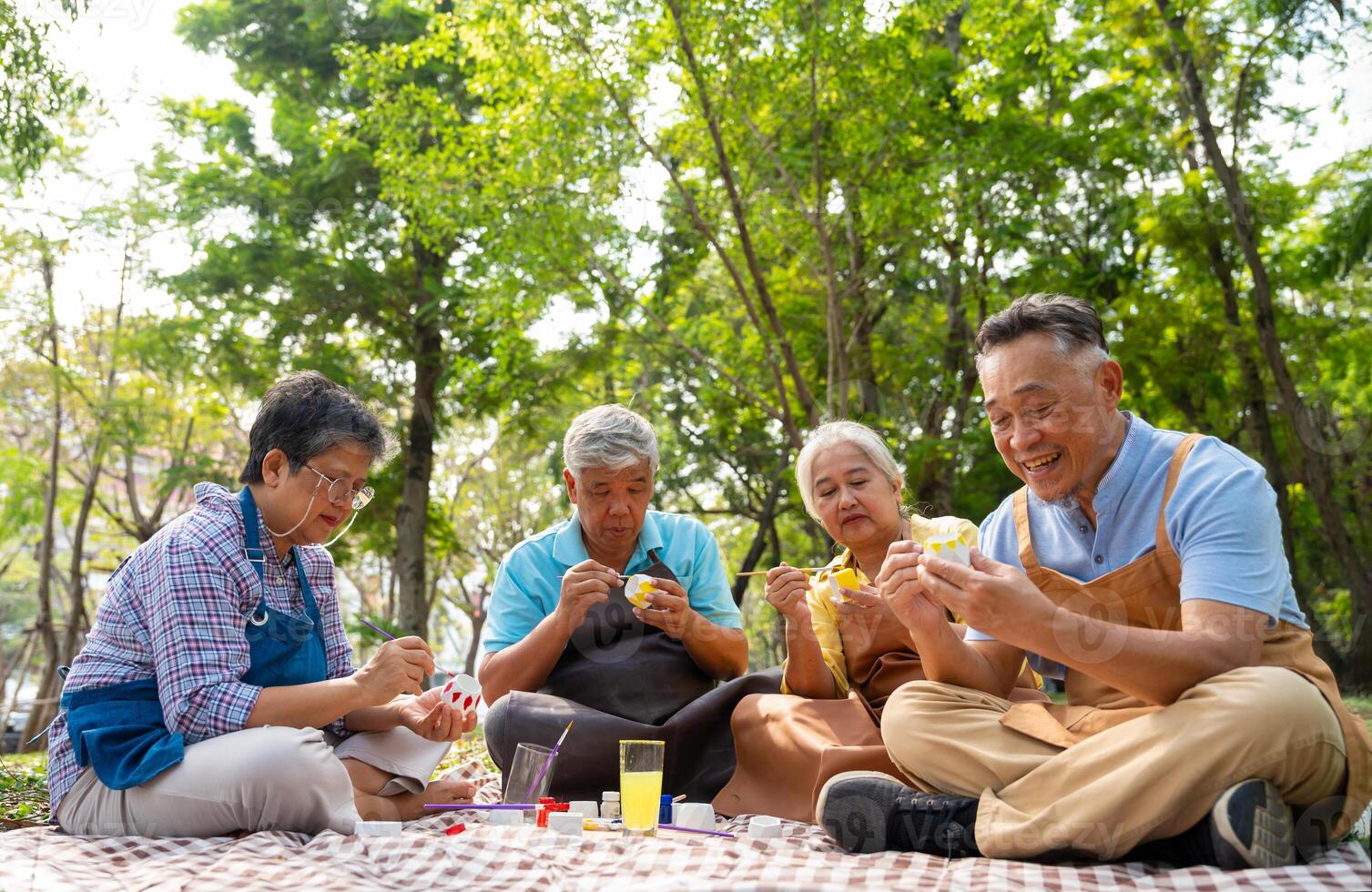 A group of Asian senior people enjoy painting cactus pots and recreational activity or therapy outdoors together at an elderly healthcare center, Lifestyle concepts about seniority photo