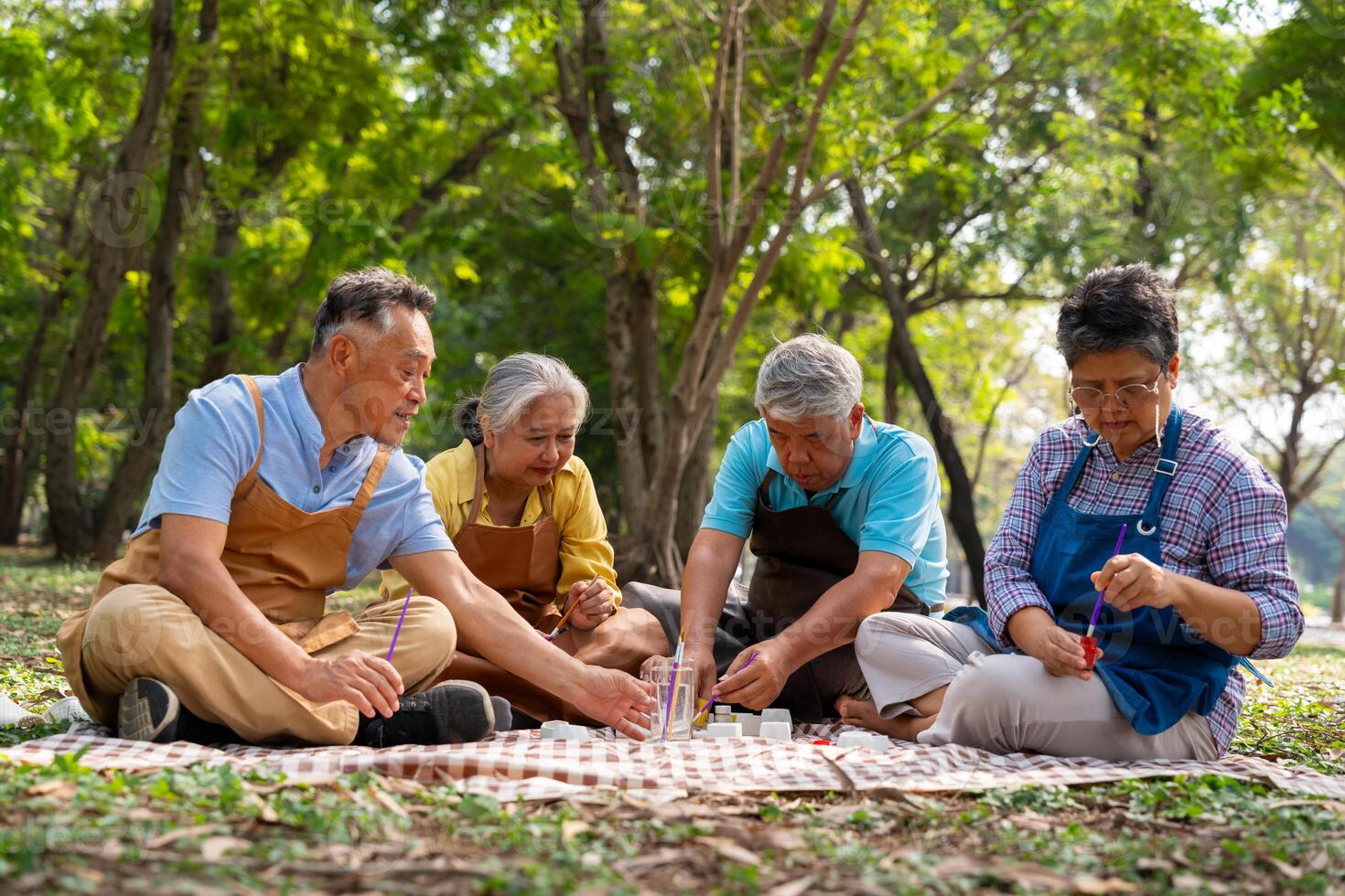 A group of Asian senior people enjoy painting cactus pots and recreational activity or therapy outdoors together at an elderly healthcare center, Lifestyle concepts about seniority photo