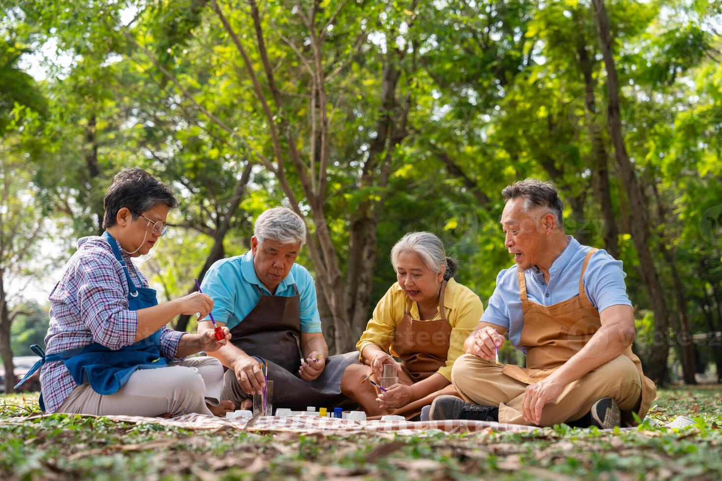 A group of Asian senior people enjoy painting cactus pots and recreational activity or therapy outdoors together at an elderly healthcare center, Lifestyle concepts about seniority photo