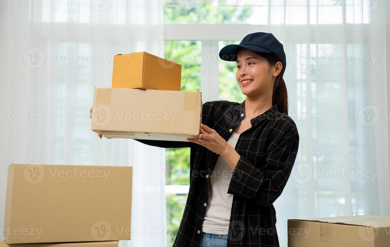 Smiling young woman holding cardboard box, Online shopping delivery concept. Online marketing and delivery. Young asian girl holding and carrying brown boxes for shipping to the client. photo