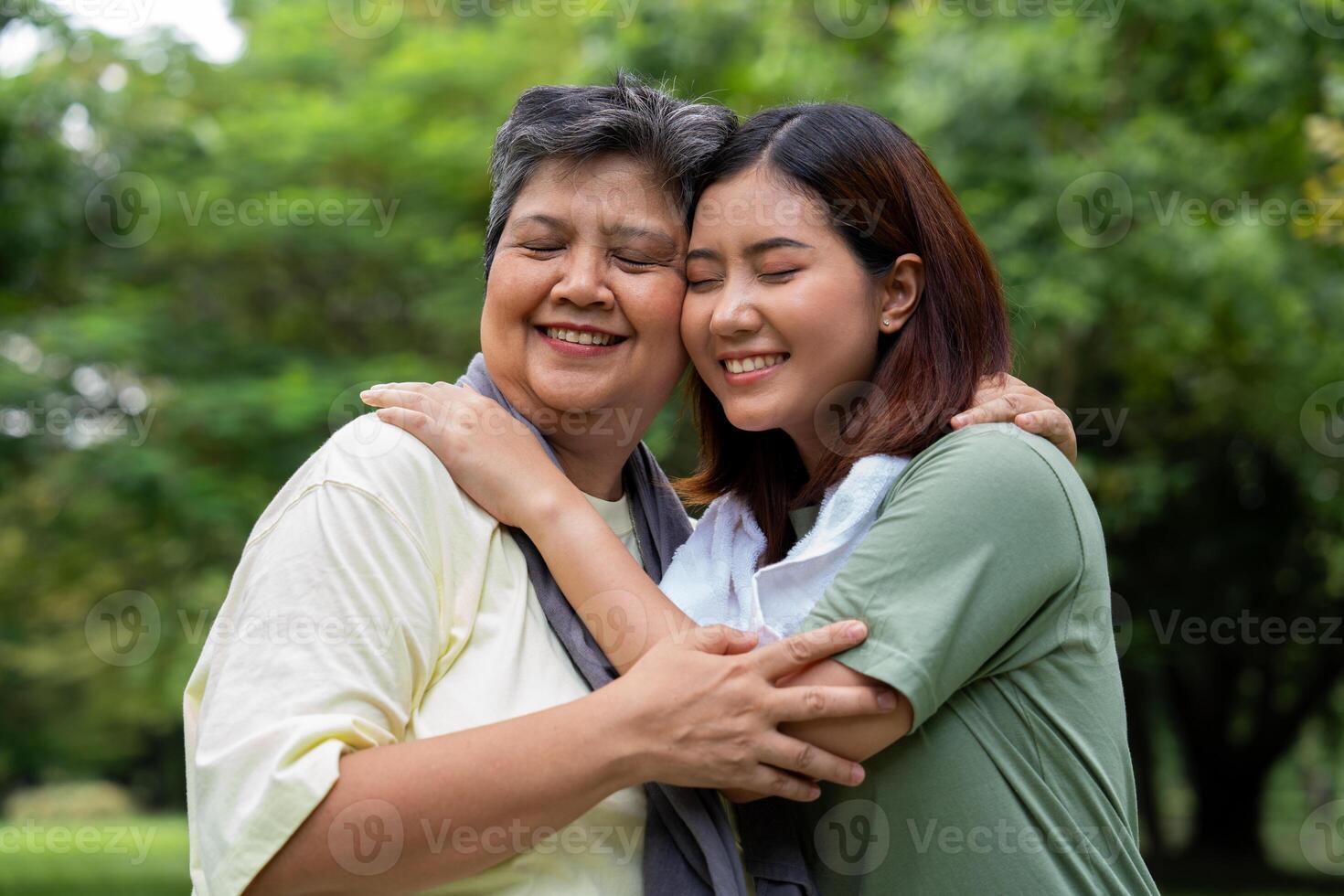 Attractive Senior mother and daughter working out together in the morning exercise in the park. The daughter Talks, smile and laughs with her mom, a senior caregiver, and a happy family concept. photo