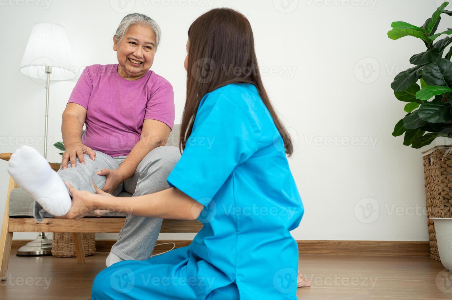 un joven asiático mujer fisioterapeuta enfermería es ayudando un mayor mujer ejercicio extensión músculos a hogar o un prima clínica para recuperación, concepto de físico terapia. foto