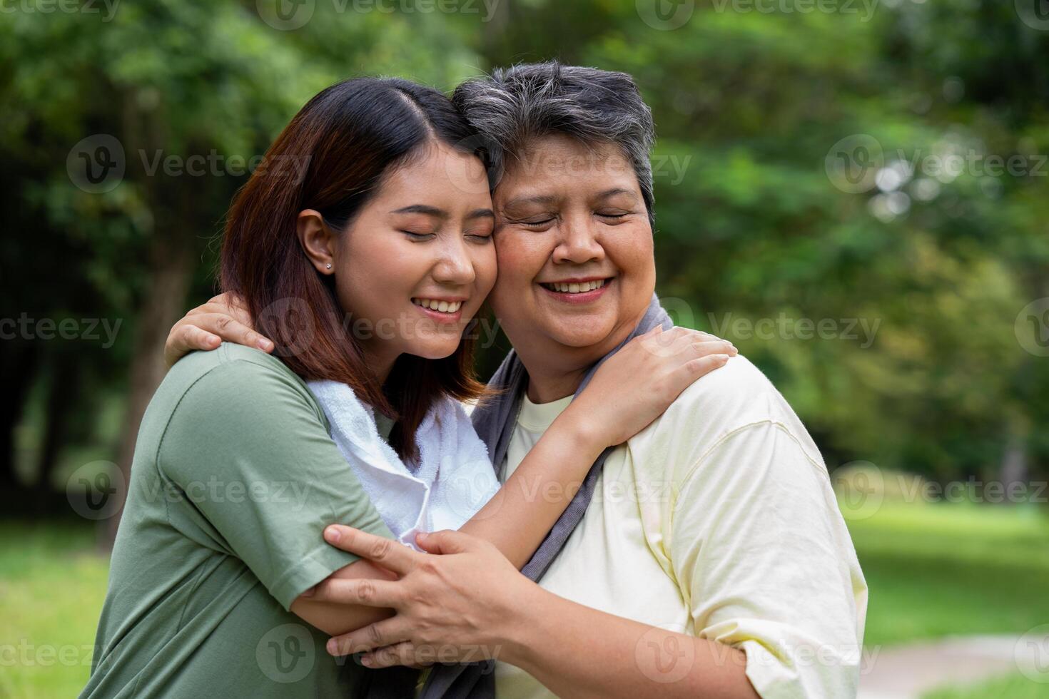 Attractive Senior mother and daughter working out together in the morning exercise in the park. The daughter Talks, smile and laughs with her mom, a senior caregiver, and a happy family concept. photo