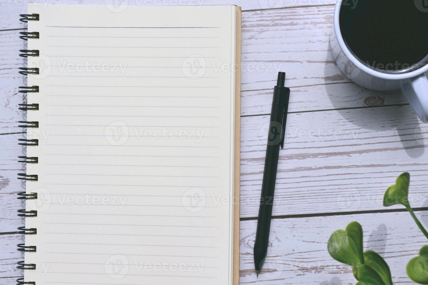 Top view of notepad and pen with cup of coffee photo