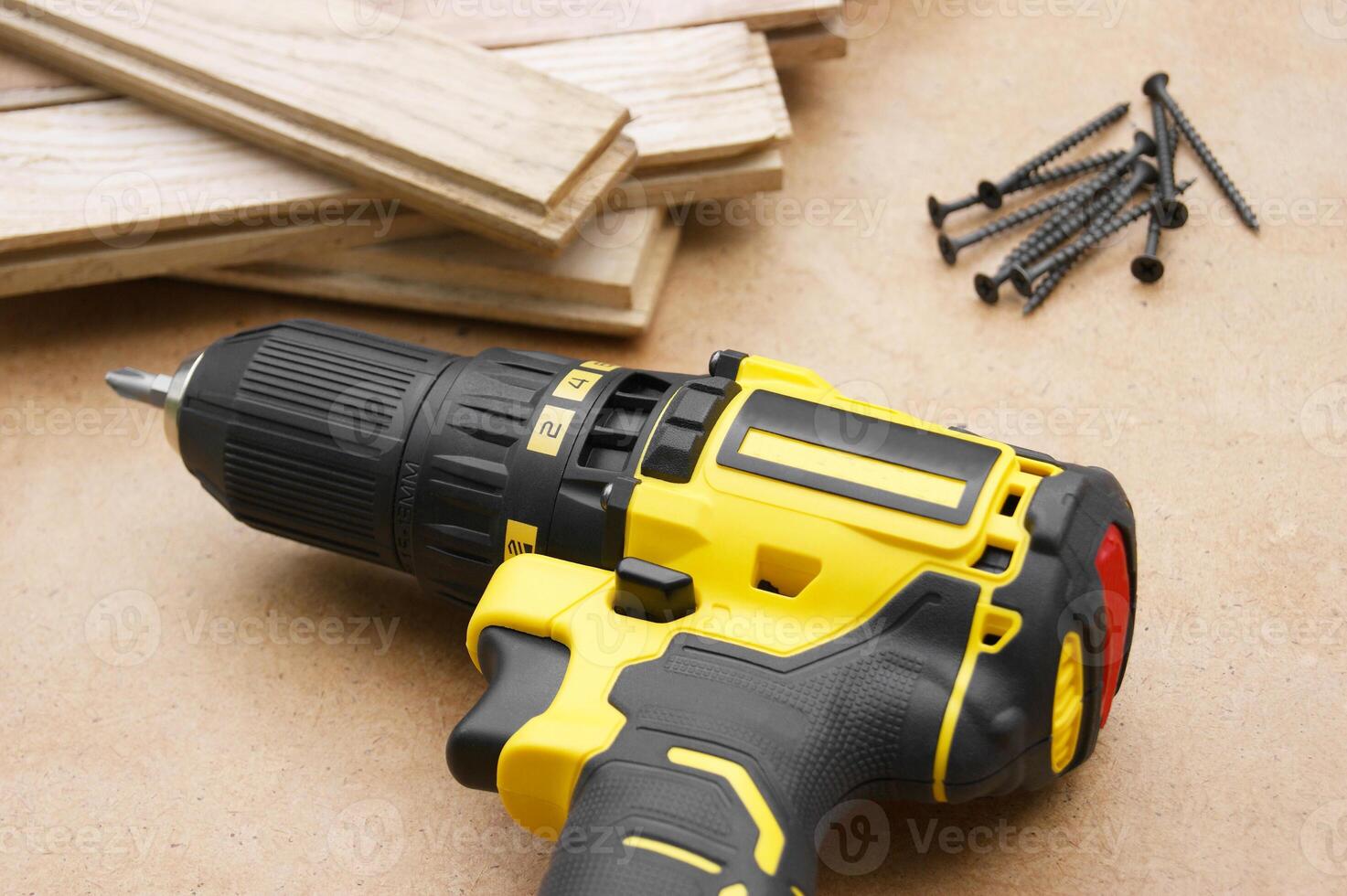 The yellow-black screwdriver on wood background, screws. photo