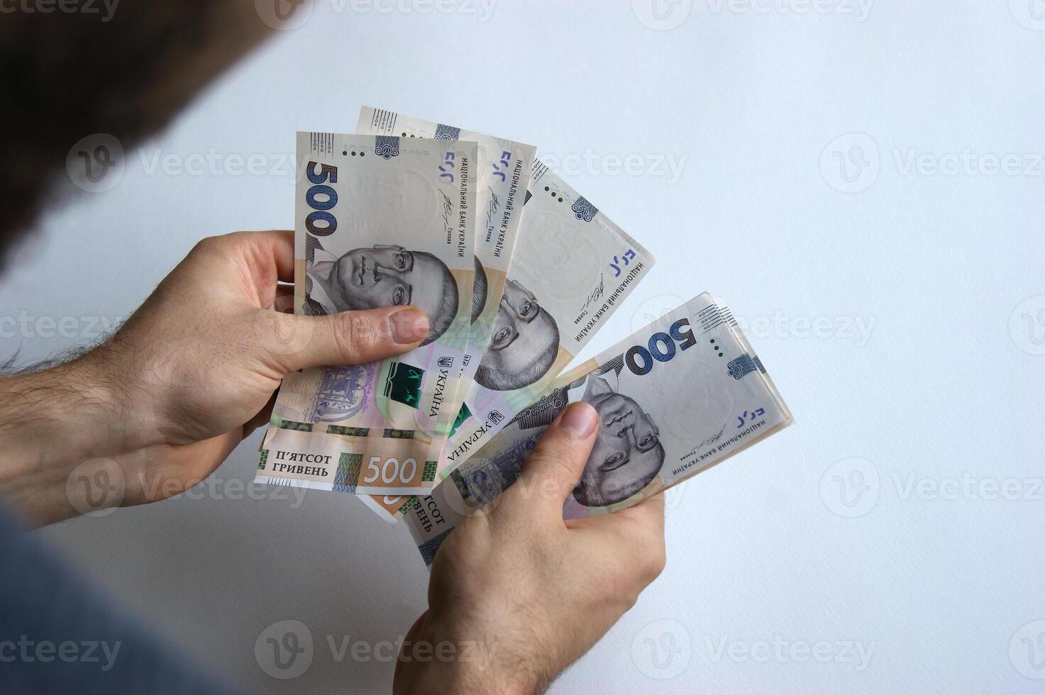 Male hand counts his money on a white table. photo